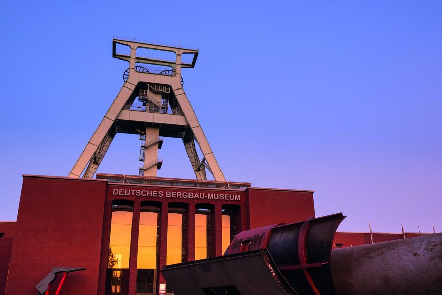 Fassade des Deutschen Bergbau-Museums Bochum mit Fördergerüst in der Dämmerung