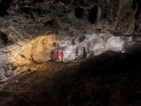 Auf diesem Bild sehen Sie zwei Forscher, die das Werk Staberer im Besucherbergwerk in Bad Dürrnberg betrachten.