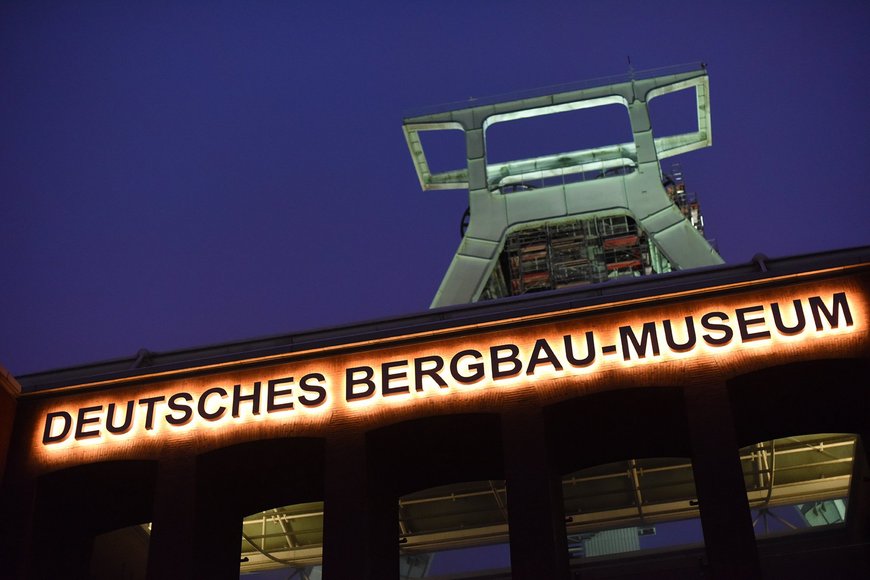 Fassade des Deutschen Bergbau-Museums Bochum mit Fördergerüst bei Nacht