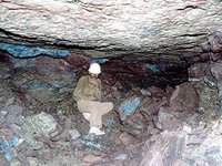 Das Bild zeigt den unter Tage aufgenommenen frühbronzezeitlichen Grubenhohlraum der Grube 7 im Wadi Khalid. Die Grube wurde von Gerd Weisgerber und Joachim Kunkel ausgegraben und vermessen. Die Höhe der Grube ist durch die Mächtigkeit der Dolomit-Kalk-Tonstein-Formation („DLS“, Burj-Kalkstein) auf ca. 1-1,5 m begrenzt. Die Grube wurde zum großen Teil direkt beim Abbau durch taubes Gestein verfüllt. Der Schacht, der von der Oberfläche zu dem Kammer-Pfeilerbau führt, ist vermutlich in römischer Zeit teilweise mit zugehauenen Gesteinsblöcken nochmals ausgebaut worden.